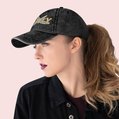 Side view of female wearing a black cap with 'CHARITY' and a fish symbol on a pink background.