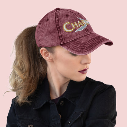 Side view of female wearing a maroon cap with 'Charity' text on a pink background