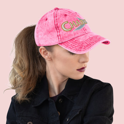 Side view of female wearing a pink cap with 'Charity' text on a pink background