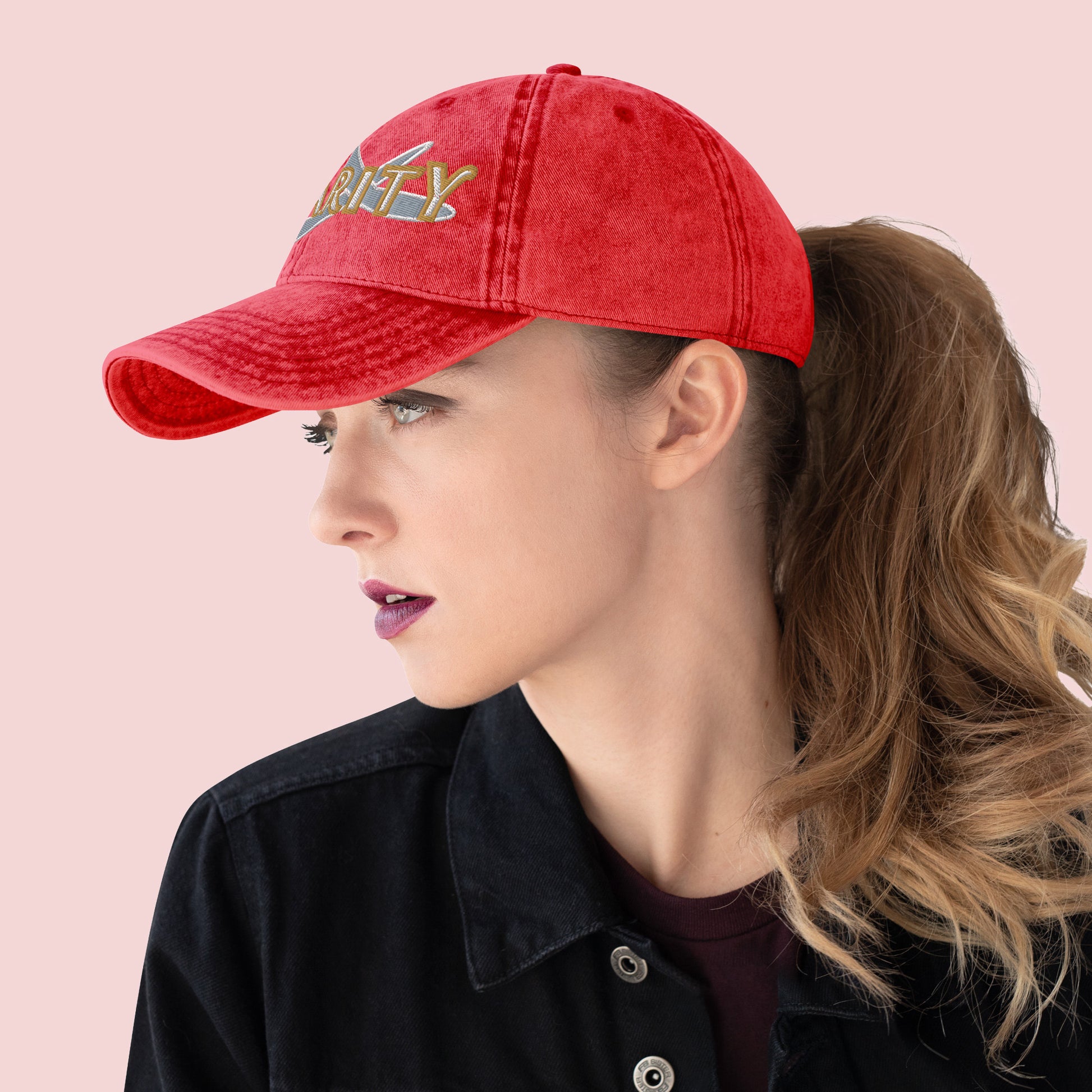 Side view of female wearing a red cap with 'Charity' text on a pink background