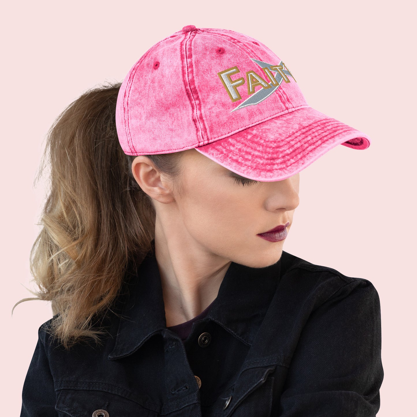 Side view of female wearing a pink cap with 'FAITH' text on a light pink background