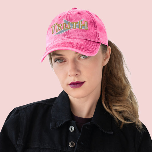 Female wearing a pink cap with 'TRUTH' text on a pink background